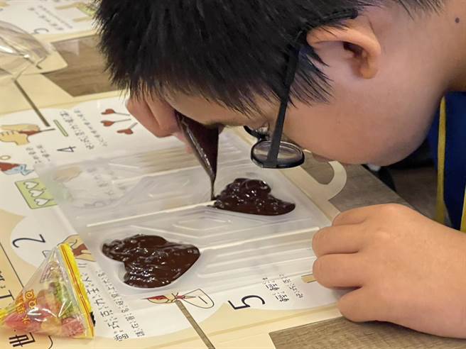 参加夏令营孩子的视力状况不一，妮娜导览员以方位引导孩子制作巧克力棒棒糖。（杨静茹摄）