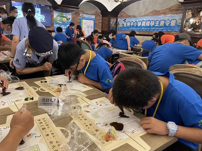 妮娜巧克力梦想城堡导览员适时提供协助，透过口说进行方位引导或伸手指引等方式，带孩子制作巧克力棒棒糖。（杨静茹摄）