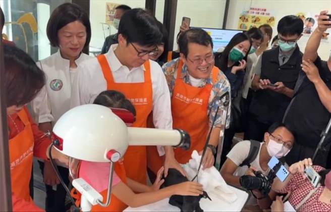 高雄市燕巢動保關愛園區的「吹狗螺」系列活動，今年暑假以「動物體驗與互動」為主題，變身為「吹狗螺渡假村」，市長陳其邁今日前往參訪、與汪喵互動，並體驗入住大飯店，也親手製作毛孩餐點，為狗狗清洗、擦拭、烘乾。（林雅惠攝）