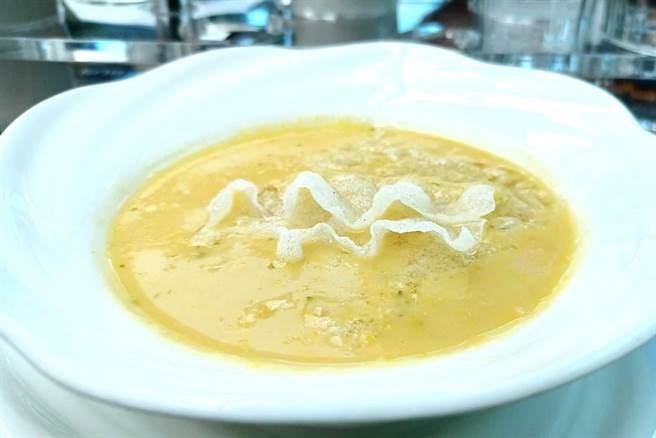 汤品「甜玉米浓汤佐海苔粉」，以高甜度的新鲜甜玉米粒融入鲜奶油及蔬菜高汤，小火慢煮15个小时，再加上炸成薄片的越南春卷皮，口感多层次。（陈韵萍摄）