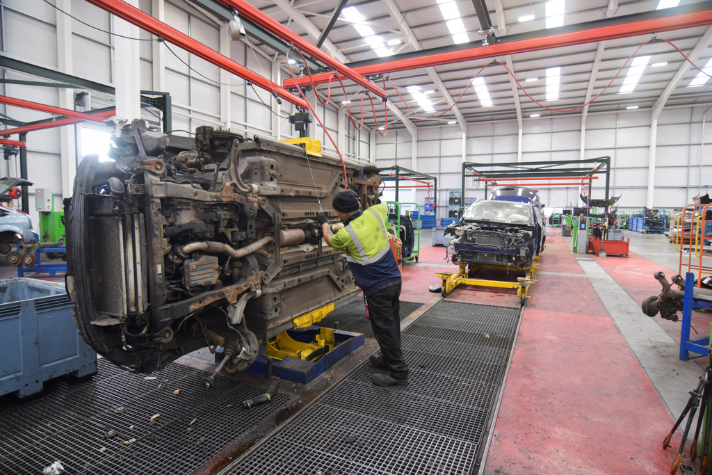 2023年6月7日，英国一间车辆拆解公司的一名工人在拆解线上拆卸旧车上的引擎，以便重新利用或回收资料照。（路透社）(photo:ChinaTimes)
