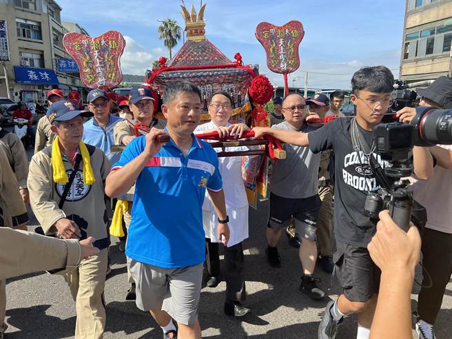 台中市大甲镇澜宫展开天上圣母遶境53庄巡安活动，妈祖銮轿22日上午来到光田综合医院大甲院区，由院长锺元强（中，白衣）接驾并和信眾一同扶轿。（潘虹恩摄）