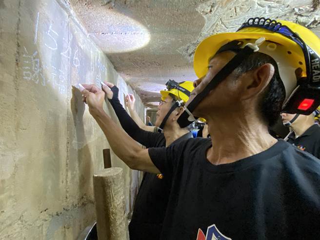 老兵们用粉笔在坑道内墙上签到，如同当年雷霆演习之情景重现。(于家麒摄)