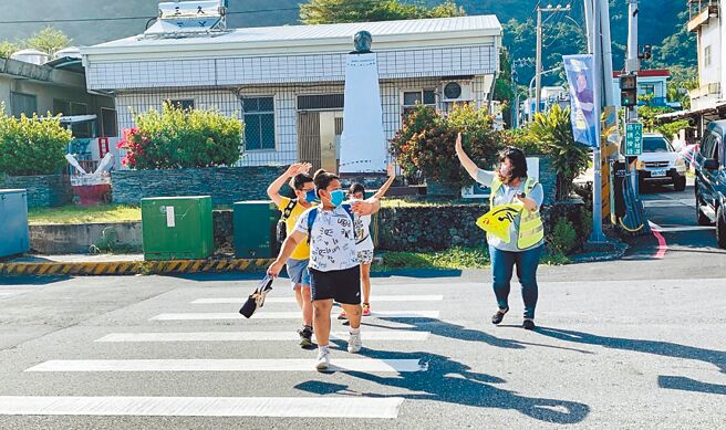 因担心交通问题，不少家长近日针对几岁才适合让孩子自己上下学展开讨论。图为台东县信义国小学生养成举手及挥手过马路的习惯。（示意图／教育部提供／李侑珊台北传真）
