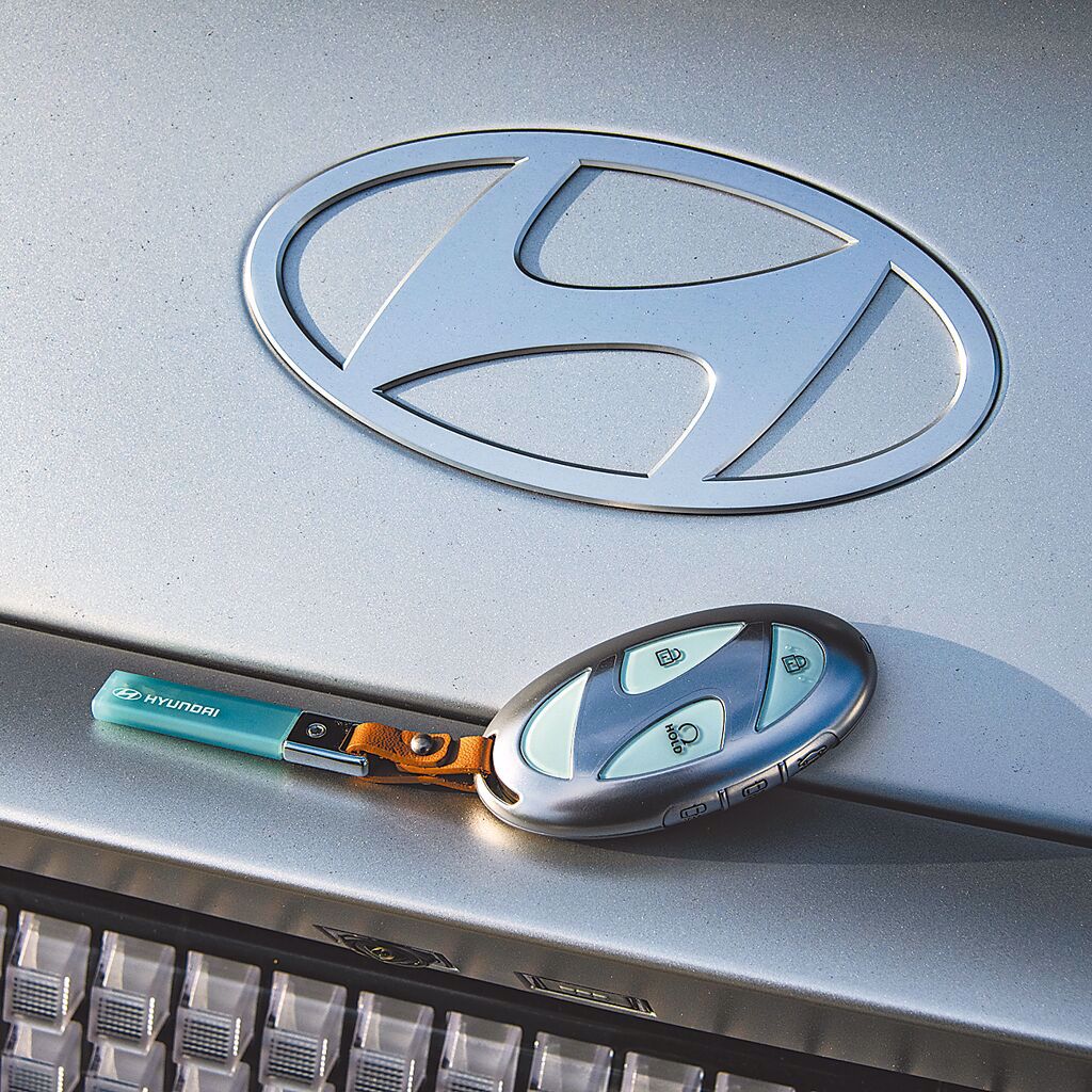 遙控鑰匙造型有如鵝卵石，內嵌有品牌logo的圖案。（陳大任攝）