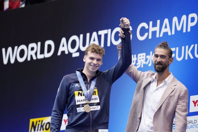法國泳將馬尚(中)奪得世錦賽個人混合400公尺金牌，獲得菲爾普斯恭賀。（美聯社）