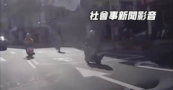 高雄行人违规过马路，还伸脚作势影响骑士通行。（摘自社会事新闻影音／崔正纲高雄传真）