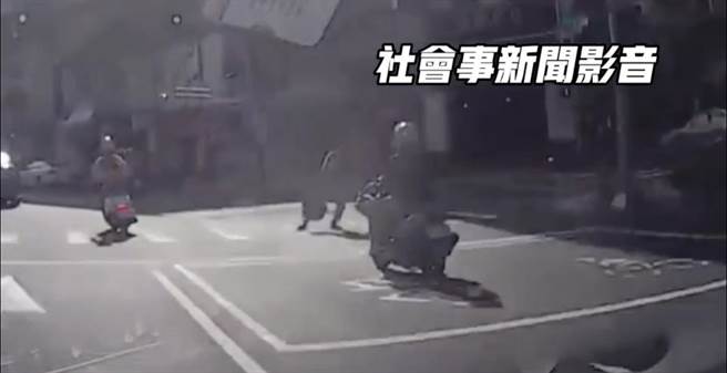 高雄行人违规过马路，还伸脚作势影响骑士通行。（摘自社会事新闻影音／崔正纲高雄传真）