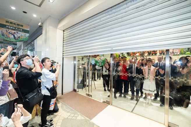 远百宝庆店拉下铁门的最后身影，与顾客挥手泪别。（石智中摄）