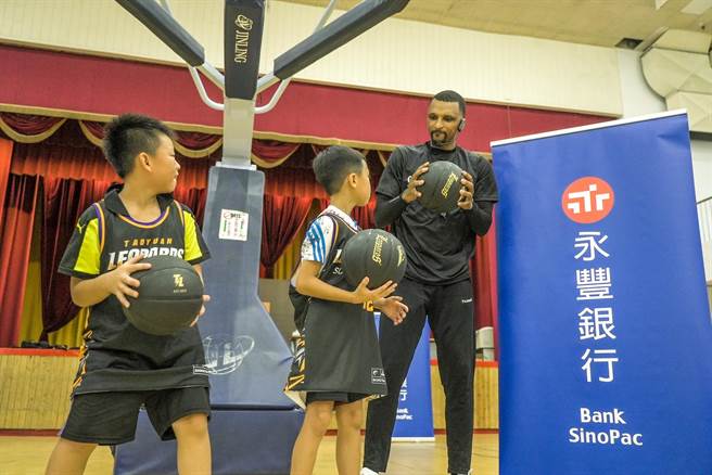 T1联盟得分王－艾夫伯（Michael Efevberha）担任教练(右一)亲自指导，激发学童对篮球运动的喜爱。（永丰提供）