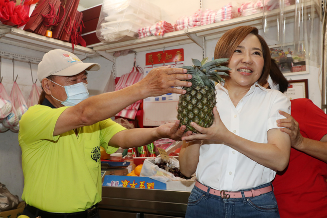 投入台北市中正、万华区立委选战的于美人（右）25日赴东三水市场扫街，寻求摊商及民眾支持，拜票过程中，一位水果摊老板送凤梨给于美人，预祝于顺利当选。（刘宗龙摄）