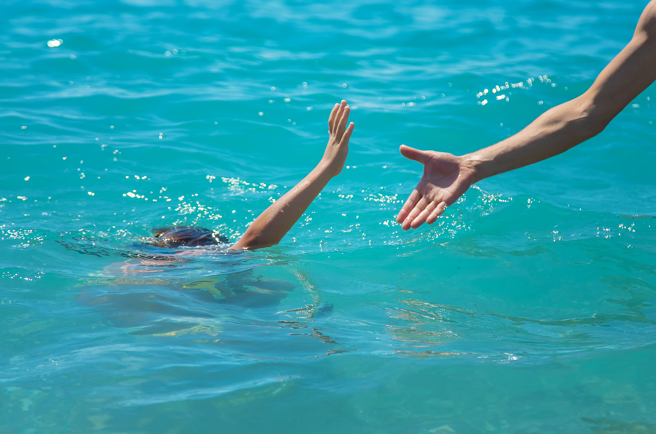 一名糊涂男子将一名女童往海里扔，女童直接跟浮力臂圈分离，消失在海面上。（示意图 Shutter Stock）