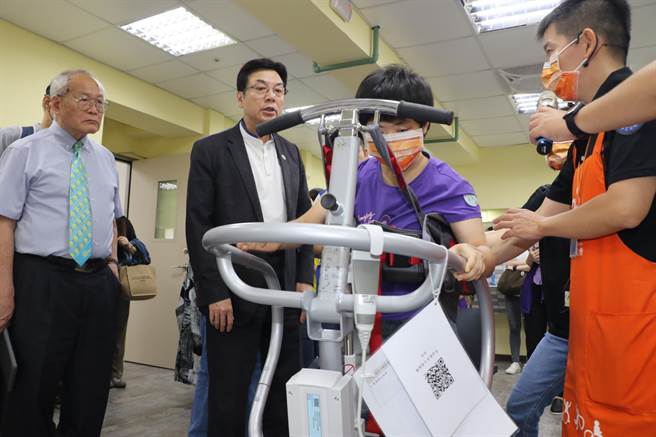职能治疗师以多功能自立復能机协助失能的学员復健。（新北市社会局提供）