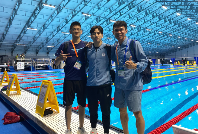 王冠閎（中）游進2023世錦賽男子200蝶決賽，創台灣泳壇新猷，和教練黃智勇（右）、物理治療師李旻軒（左）合照。（黃智勇提供／陳筱琳台北傳真）
