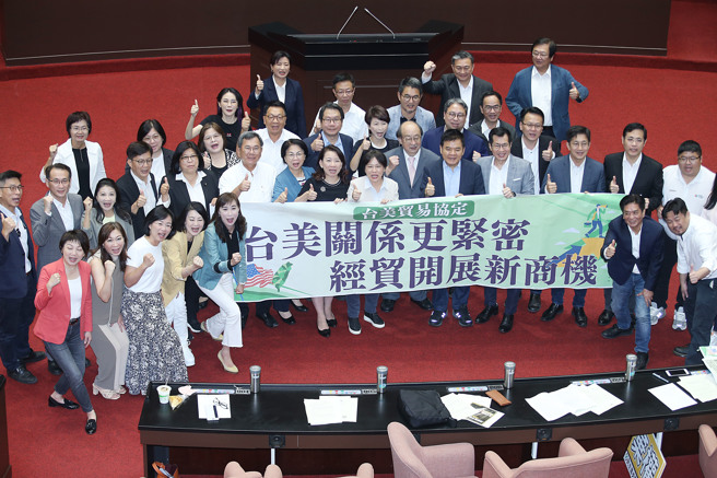 立法院26日临时会通过「台美21世纪贸易倡议」首批协定，民进党立委在议场内拉起布条合影留念。（姚志平摄）