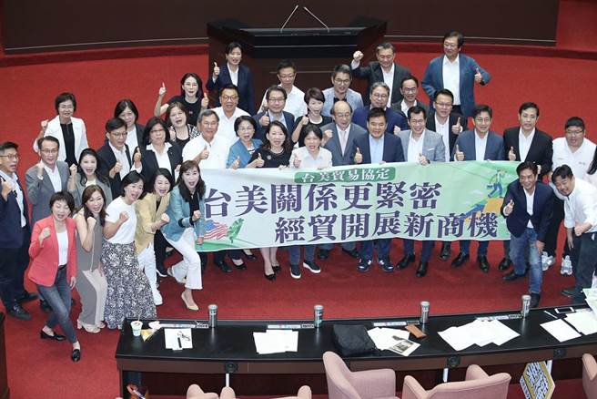 立法院26日临时会通过「台美21世纪贸易倡议」首批协定，民进党立委在议场内拉起布条合影留念。（姚志平摄）