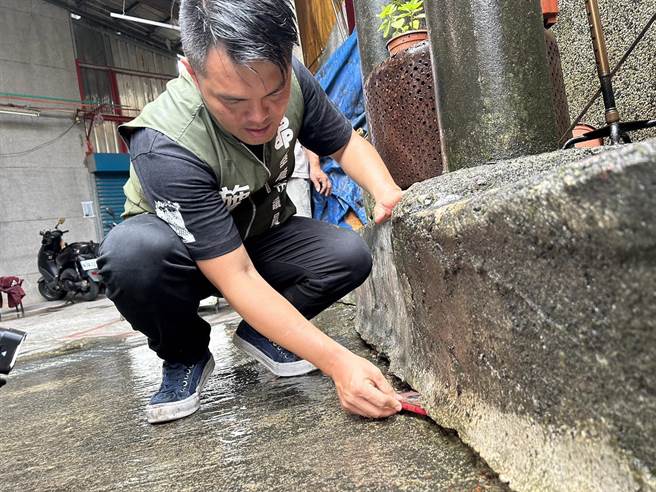 市议员施伟政指出，地基掏空的裂缝已经大到可以塞入手机。（基隆市议员施伟政提供／徐佑升基隆传真）