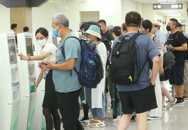 松山机场的航空公司柜台，地勤人员协助登机的乘客报到。（粘耿豪摄）