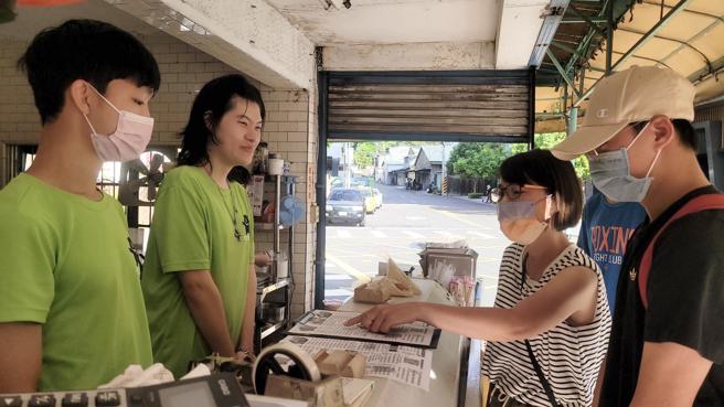 志工们走入社区，到早餐店当起点餐的服务人员，与民眾用英语沟通。（图／高雄市教育局）