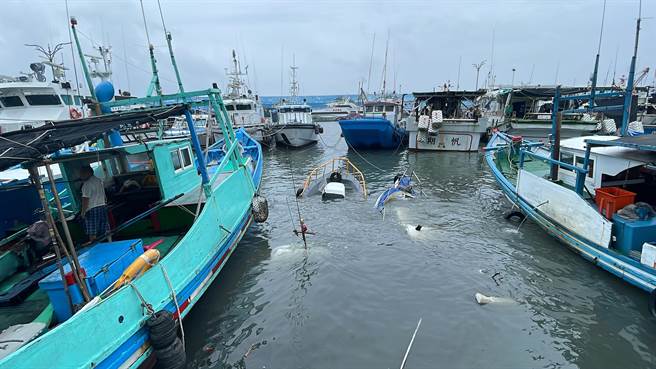 為避免船隻沉入港底隨波漂流，造成更多漁船刮損，現由兩側的漁船用繩索拉緊支撐。（蕭嘉蕙攝）