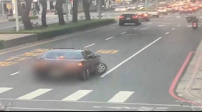 轿车右前轮突然脱落，车上夫妻俩见状立即煞停，但轿车卡在路中动弹不得。（翻摄照片／崔正纲高雄传真）