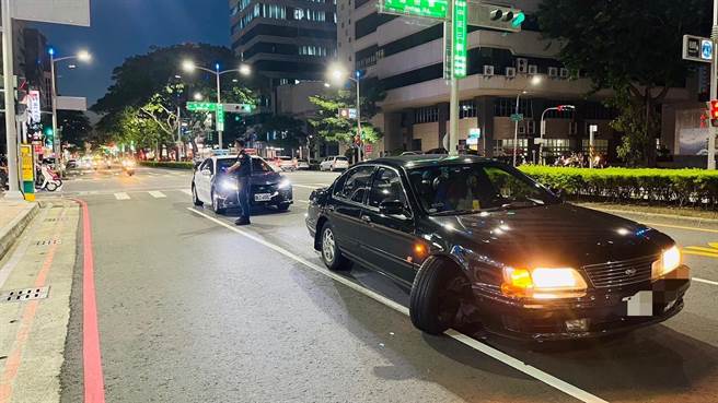 轿车右前轮突然脱落，车上夫妻俩见状立即煞停，但轿车卡在路中动弹不得。（翻摄照片／崔正纲高雄传真）