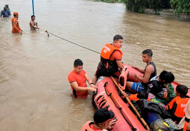 7月26日，菲律宾北伊罗戈省，杜苏芮颱风引发多数地区淹水，海巡署成员救援巴卡拉（Bacarra）居民。（路透社）