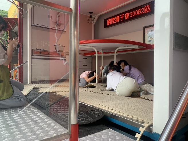 新北市消防局今年与长荣海事博物馆合作，携手办理「2023年第十四届航海探险王夏令营-海陆安全任我行」活动，学童地震体验车。（图／新北消防局提供）