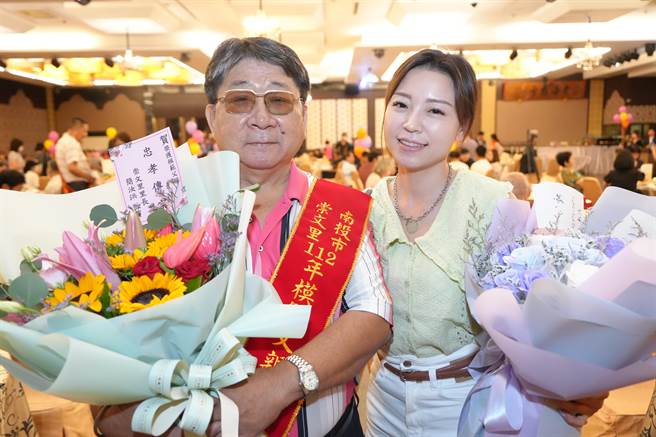 今年68岁的南投市崇文里模范父亲陈新渊今天在女儿陪同下领取奖牌与鲜花。南投市公所提供