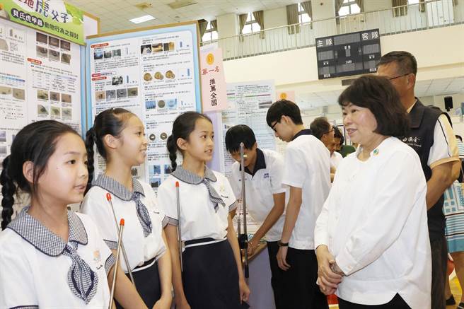 嘉义市长黄敏惠（右）讚赏崇文国小作品「飞天遁地虎父子─贝氏虎甲虫动物行为之探讨」。（嘉义市政府提供／廖素慧嘉市传真）