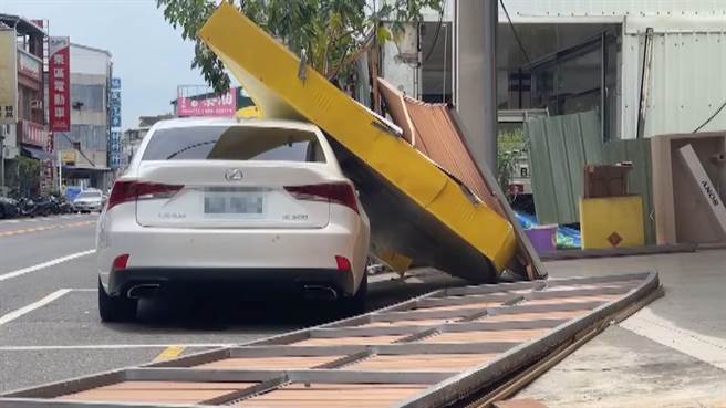 台东3C连锁卖场招牌掉落砸中日系百万名车，造成车顶受损、右侧车身烤漆刮伤，地面上还有3片被扯下的铁制看板。（民眾提供／萧嘉蕙台东传真）