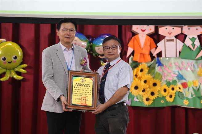 埔里國中校友會理事長張克士（左）頒發特殊貢獻獎給已故的黃茂松校友，由黃茂松的兒子黃碩基代為接受。埔里國中校友會提供