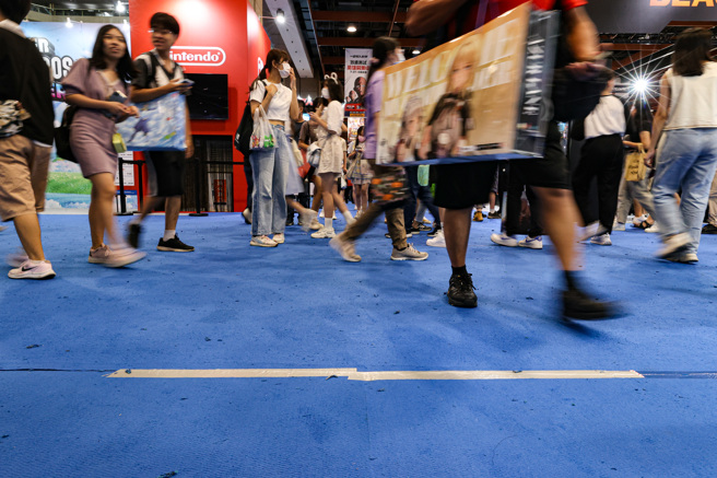 2023第22届漫画博览会27日起至31日在台北世贸一馆展开，主办单位预估展期进场人次将突破60万人。适逢周末，现场人潮眾多，主办单位适时修补地毯，地上处处是胶带痕迹。（中央社）