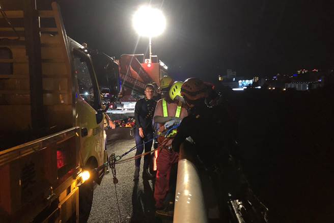 消防人员于高速公路桥吊挂，将2名受困沙洲移工救出。（新竹县消防局提供／罗浚滨新竹传真）