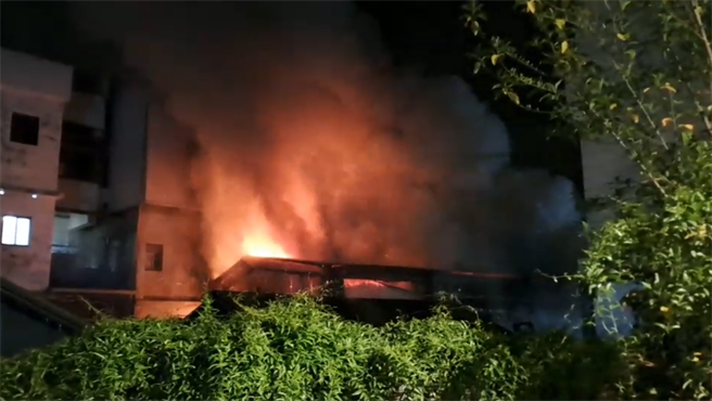 花莲玉里镇一间废金属处理厂今天凌晨突然起火燃烧，火舌不断随浓烟从中窜出，照亮整条街道，现场相当惊险。（花莲县消防局提供／罗亦晽花莲传真）