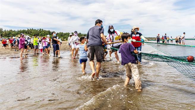 竹北市新月沙灣海洋音樂祭去年舉辦的牽罟活動，大小朋友合力將漁網拉上岸。（羅浚濱攝）