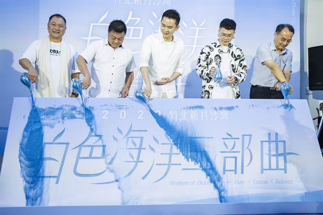 竹北市長鄭朝方（中）等人以流沙方式顯現「白色海洋三部曲」，強力宣傳新月沙灣連續3個周末的活動。（羅浚濱攝）