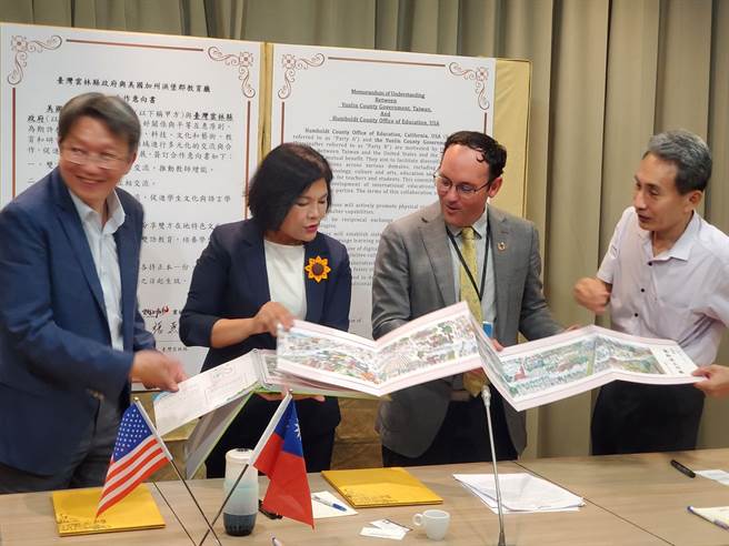 云林县长张丽善（左二）向美国加州洪堡郡（Humboldt County）教育厅副厅长司马特（右二）展示云林县国小学童接力绘成的云林溪上河图，左一是中正大学教研究所长郑胜耀，右一是云林县府教育处长邱孝文。（周丽兰摄）