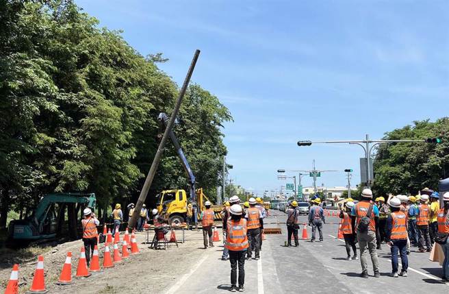 屏鵝公路為改善景觀實施桿線地下化種樹百里工程，圖為2022年夏天拔除首支電桿，工程人員紛紛拿出手機記錄。（資料照，台電提供／林和生屏東傳真)
