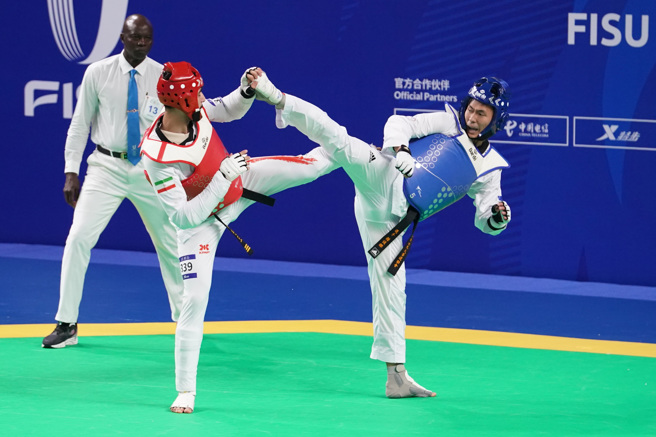 跆拳道好手锺俊杰(右)在成都世大运四强赛击败乌兹别克选手闯进金牌战。(大专体总提供／黄邱伦台北传真)