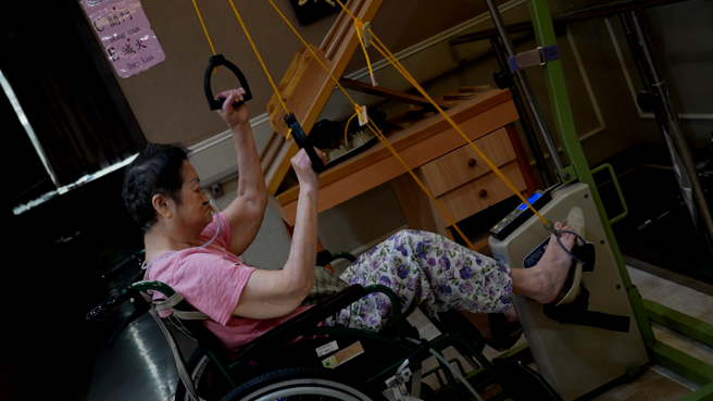 无法站立的长辈也能利用復健器材训练关节灵活度。(图/何祥瑀)