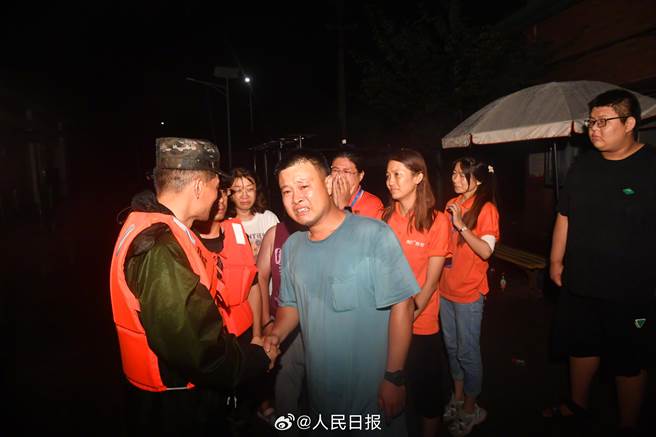 滞留2天2夜的K396乘客陆续脱困：这一刻，泪眼婆娑。 图为在武警队员护送下，第一批旅客开始向山下转移，连夜步行前往斜河涧车站。（人民日报）