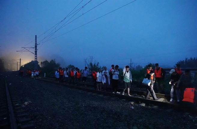 滞留2天2夜的K396乘客陆续脱困：这一刻，泪眼婆娑。 图为在武警队员的护送下，第一批旅客开始向山下转移，连夜步行前往斜河涧车站。（大陆央视）