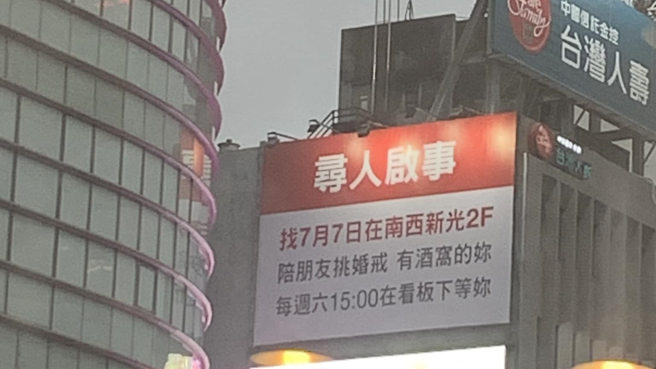 一名女子在北市中山区某处高楼看到新的大大的寻人启事看板。（图／网友授权提供）