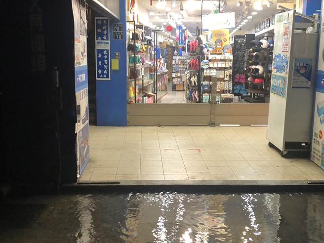 ▲店家發現積水情形趕緊裝上防水柵門預防淹水。（基隆市政府提供／徐佑昇基隆傳真）