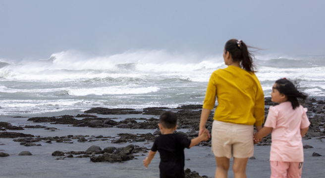 卡努颱風的暴風圈3日逐漸接近台灣陸地，適逢大潮，有民眾不畏風雨前往新北石門風景區觀浪。（張鎧乙攝）