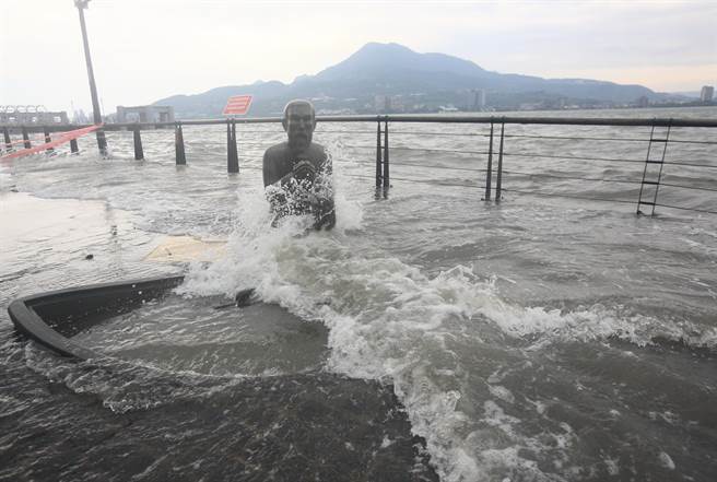 卡努颱风的暴风圈3日逐渐接近台湾陆地，适逢大潮，新北市淡水老街马偕艺术铜像周边水位高涨。（张铠乙摄）
