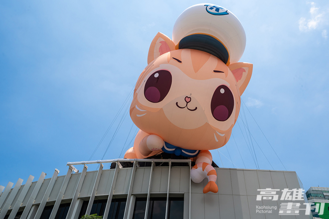 「蜜柑站长」拿着牠最爱的虾虾，现身轻轨真爱码头站旁的高流海豚建筑上。(摄影/黄敬文)