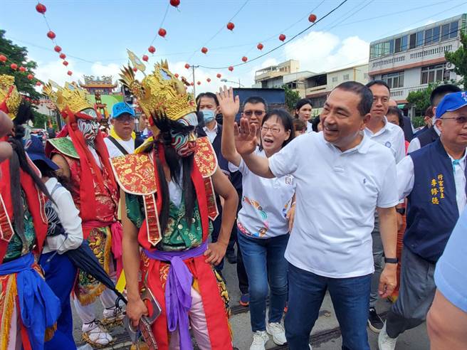侯友宜抵达时刚好遇到外地香客进香，他主动与八家将成员打招呼。（周丽兰摄）