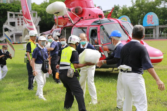 慈济志工、南投市的嘉和与营南社区共出动近50名志工，在现场帮忙包裹清点物资，并协助送上直升机。(慈济提供)